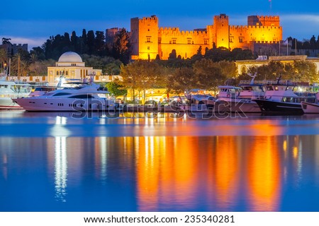 Mandraki Harbour Rhodes Greece and The Palace of the Grand Master of the Knights of Rhodes at night.