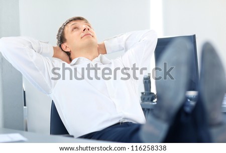 businessman relaxing at the office with his shoes on the desk