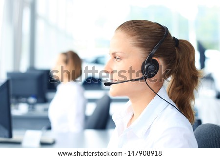 Beautiful Young Female Call Center Operator With Headset In Office