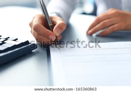 Businesswoman Sitting At Office Desk Signing A Contract With Shallow Focus On Signature