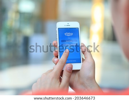 MINSK, BELARUS - JULY 05, 2014: Woman holding brand new black Apple iPhone 5S. Skype is a voice-over-IP service and instant messaging client.