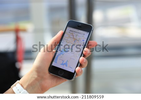 MINSK, BELARUS - AUGUST 17, 2014: Woman holding on Google Maps application on new black Apple iPhone 5S. Google Maps is most popular mapping service for mobile provided by Google.