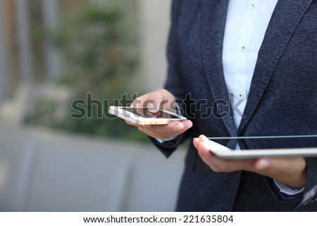 Young businesswoman working with modern devices, digital tablet computer and mobile phone