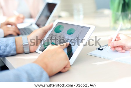 Business person analyzing financial statistics displayed on the tablet screen