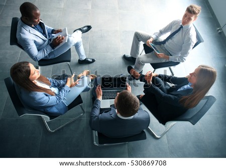 Creative business people meeting in circle of chairs