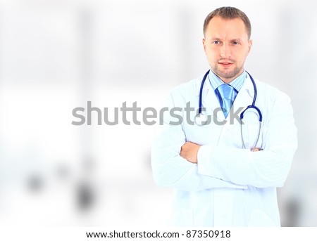 Frontal portrait of doctor in white coat and stethoscope with arms crossed