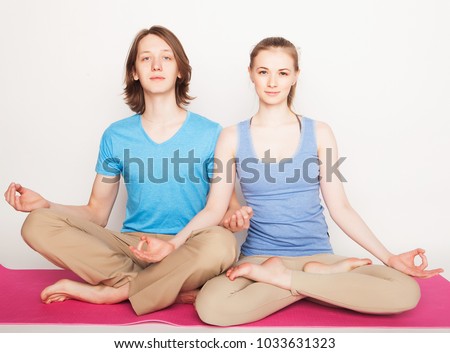 lifestyle, sport  and people concept: Young couple in yoga pose over white background