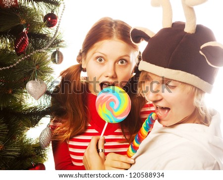 Christmas. two funny girls with lolly-pop.