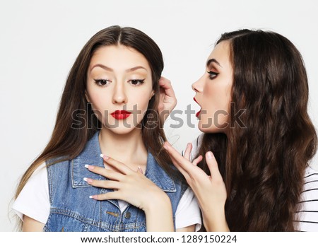lifestyle, emotion and people concept: Portrait of two happy young women sharing secrets isolated over white  background