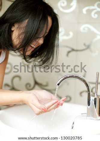 A woman washing her hands in the sink