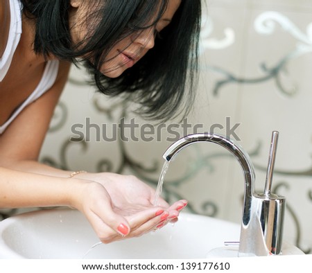 A woman washing her hands in the sink