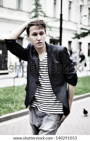 young fashion man in casual wear. posing on the street.