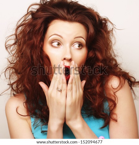 Young woman with hands over mouth. Surprise!