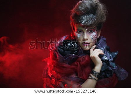 Close up portrait young woman with bright fantasy make up over red background