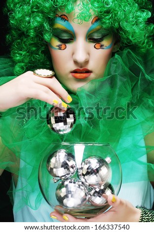 Beautiful lady with artistic make-up holding Christmas decorations.Doll style.