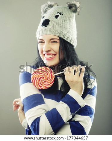 funny woman with winter hat holding big lollipop
