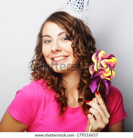 Funny curly woman  holding big lollipop. Birthday party.
