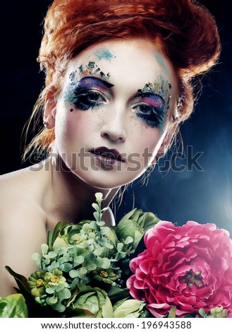Young beautiful redhair woman with bright creative visage holding flowers