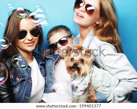 happy two sisters and brother with yorkshire terrier