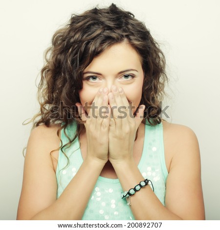 Beautiful young woman covering the face with her hand