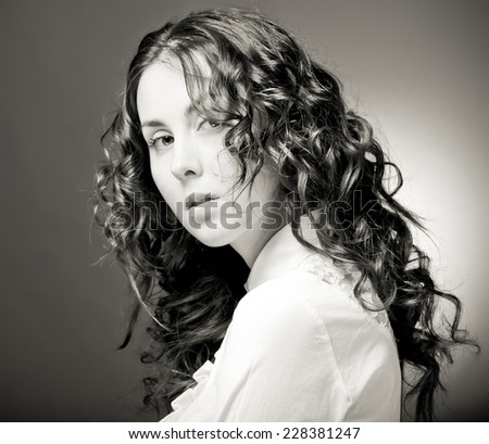 Portrait of pretty young woman with curly hair. Sepia tone.
