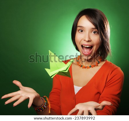young expression woman with paper bird over green background