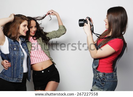 A girl takes picture of her friends. Concept of friendship and fun.Best friends enjoying the moment with modern camera.