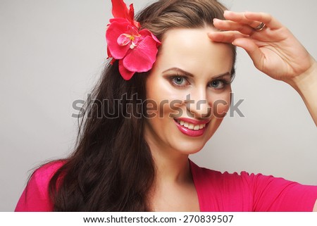 young happy woman with pink flower in the hair