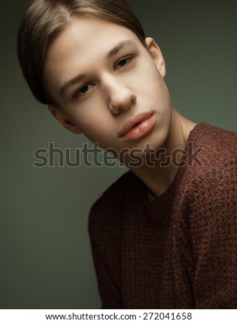 A young teenage boy being photographed in a studio.