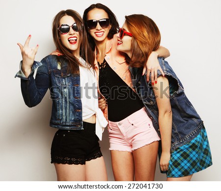 Fashion portrait of three stylish sexy hipster girls best friends, over gray background. Happy time for fun.