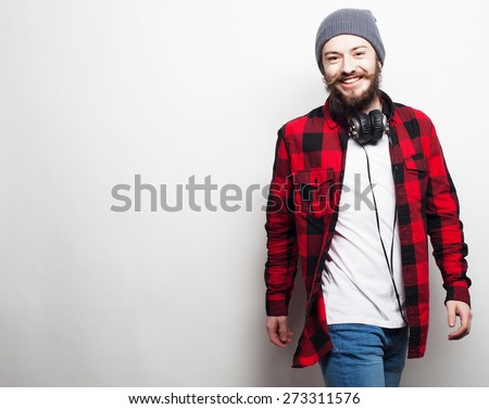 emotional and people concept: young bearded man wearing hat with headphones