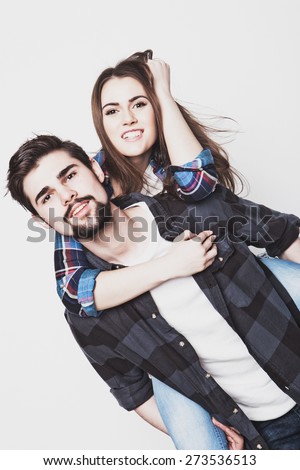 emotional, life style, happiness and people concept: Happy loving couple. Young man piggybacking his girlfriend. Studio shot over white background.Special Fashionable toning photos.