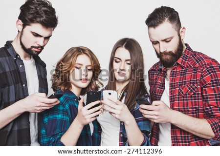 technology and internet concept:group of young people  looking at their smartphones