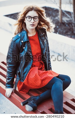 Girl Sitting on Bench. Street Fashion. Urban Lifestyle. Young Beautiful Woman Walking Outdoor.Image toned.