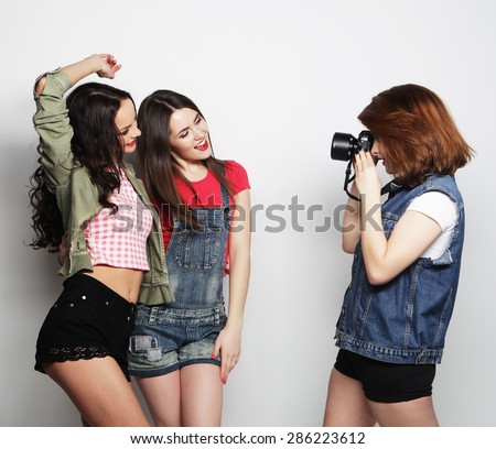 A girl takes picture of her friends. Concept of friendship and fun.Best friends enjoying the moment with modern camera.