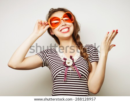 Party image. Playful young woman with big party glasses and crown. Ready for good time.