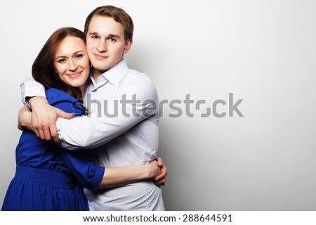 Love, family and people concept: lovely happy couple hugging over grey background.