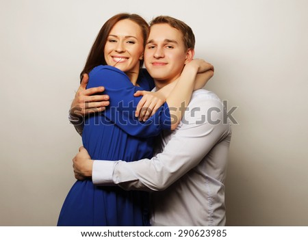 Love, family and people concept: lovely happy couple hugging over grey background.