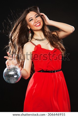 Young sexy woman in red dres keeping disco ball