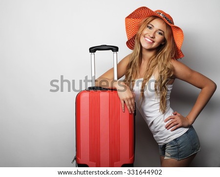 Portrait of  young woman wearing big straw orange hat  standing with orange travel bag