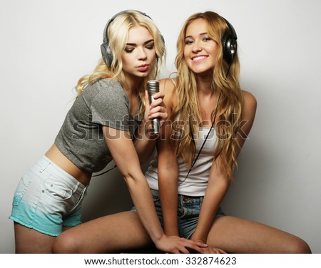 life style, happiness, emotional and people concept: beauty hipster girls with a microphone singing and having fun