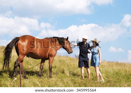 Young couple in love outdoor.Stunning sensual outdoor portrait of young couple posing in summer sunset near horse.