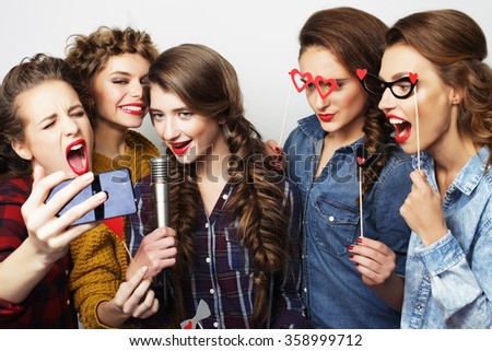 beautiful stylish hipster  girls singing karaoke