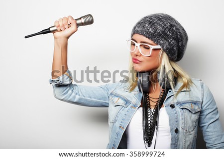 Beautiful young woman with microphone and headphones