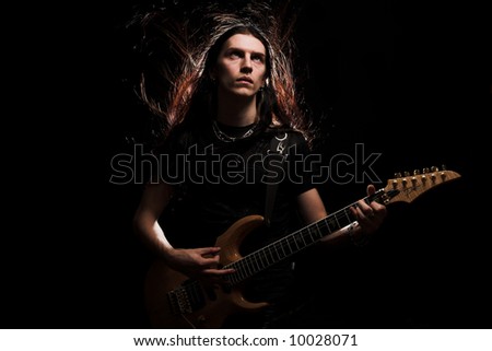 man playing electrical guitar. wind in hair.