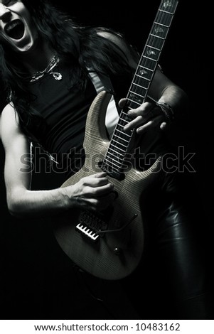 man with long hair playing electrical guitar.Black and white.