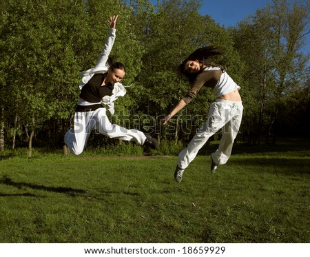 two girl jumping in park