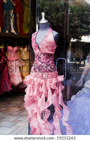 Close-up shot of the store window with a mannequin dressed in fashionable gown