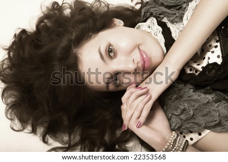 stock photo : Young woman with long brown curly hair and green eyes laying 
