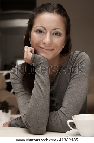 Portrait of smiling woman resting her chin on hand